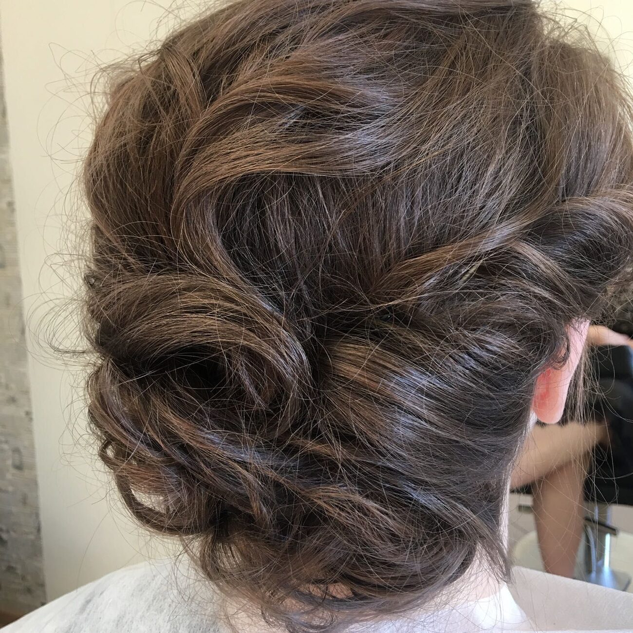 Eleganckie upięcie z falami na ciemnych włosach